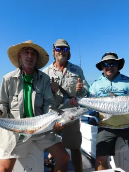 men posing for the camera holding up the fish they caught with airlie beach fishing charters in airlie beach, queensland