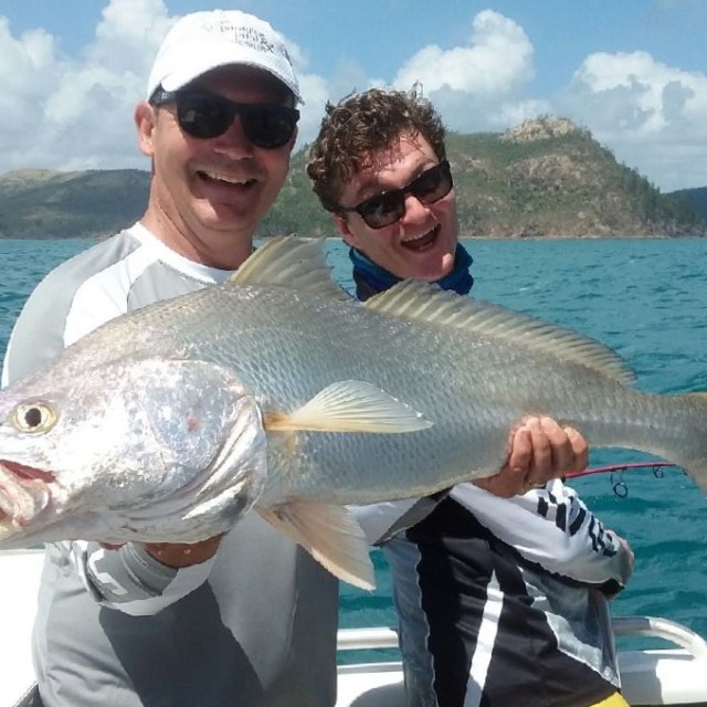 men posing for the camera holding up the fish they caught with airlie beach fishing charters in airlie beach, queensland